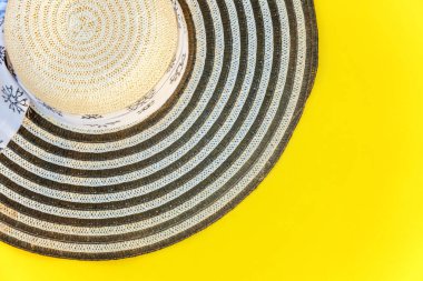 Düz Lay sarı renkli şık modern moda arka plan üzerinde çizgili retro şapka ile. Tatil seyahat yaz hafta sonu deniz macera seyahat kavramı