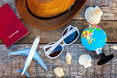 Düz şapka, uçak, pasaport, dünya, güneş gözlüğü ve kabuk rustik trendy eski vintage ahşap zemin üzerine yatırın. Tatil seyahat yaz hafta sonu deniz macera seyahat kavramı
