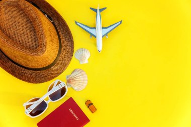 Düz şapka, uçak, pasaport, güneş gözlüğü ve kabuk sarı renkli şık modern moda zemin üzerine yatırın. Tatil seyahat yaz hafta sonu deniz macera seyahat kavramı