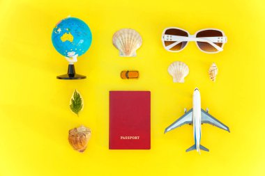 Uçak, pasaport, dünya, güneş gözlüğü ve kabuk üzerinde sarı renkli şık modern moda arka plan düz yatırın. Tatil seyahat yaz hafta sonu deniz macera seyahat kavramı