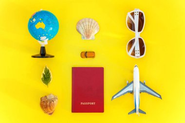 Uçak, pasaport, dünya, güneş gözlüğü ve kabuk üzerinde sarı renkli şık modern moda arka plan düz yatırın. Tatil seyahat yaz hafta sonu deniz macera seyahat kavramı