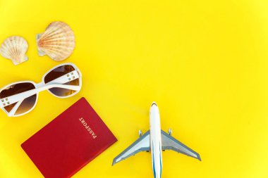 Uçak, pasaport, güneş gözlüğü ve kabuk üzerinde sarı renkli şık modern moda arka plan düz yatırın. Tatil seyahat yaz hafta sonu deniz macera seyahat kavramı