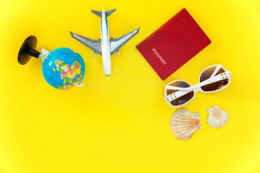 Uçak, pasaport, dünya, güneş gözlüğü ve kabuk üzerinde sarı renkli şık modern moda arka plan düz yatırın. Tatil seyahat yaz hafta sonu deniz macera seyahat kavramı