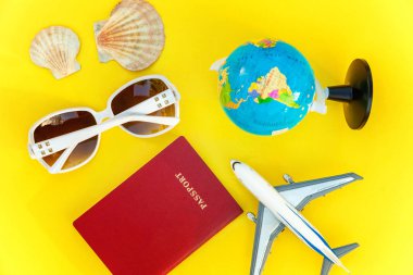 Uçak, pasaport, dünya, güneş gözlüğü ve kabuk üzerinde sarı renkli şık modern moda arka plan düz yatırın. Tatil seyahat yaz hafta sonu deniz macera seyahat kavramı