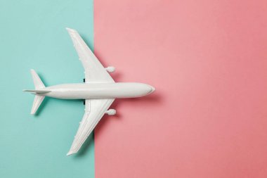 Sade bir şekilde yatıyordu tasarım minyatür oyuncak model uçak mavi ve pembe pastel renkli kağıt trendy geometrik arka plan üzerinde düz. Uçak tatil yaz hafta sonu deniz macera seyahat kavramı ile seyahat