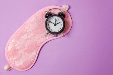 Göz maskesi, mor menekşe pastel renkli şık arka plan üzerinde izole çalar saat uyuyor. Beni rahatsız olmaz, bırak uyuyayım. Dinlenme, iyi geceler, siesta, uykusuzluk, gevşeme, yorgun, kavram seyahat