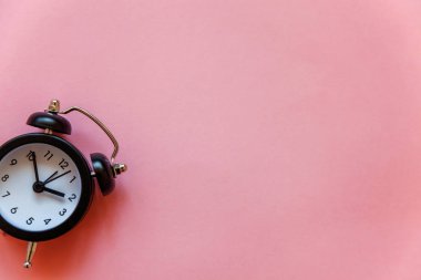 İki Yataklı çan vintage klasik çalar saat göl kenarında pembe pastel renkli şık arka planda çalıyor. Saat bekletin, Günaydın gece, hayat, zaman, uyanık kavramı uyandırma. Düz yatıyordu, en iyi görünüm, kopya alanı