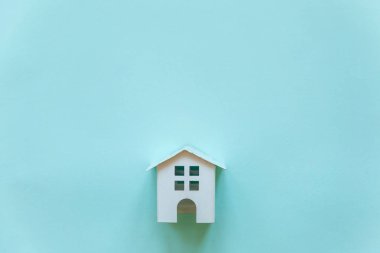 Minyatür beyaz oyuncak ev mavi pastel renkli kağıt trendy arka plan üzerinde sadece düz yatıyordu tasarım. Mortgage Emlak sigorta rüya ev concept. Düz yatıyordu, en iyi görünüm, kopya alanı