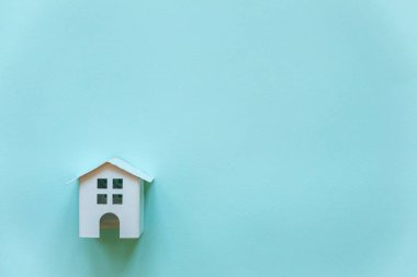 Minyatür beyaz oyuncak ev mavi pastel renkli kağıt trendy arka plan üzerinde sadece düz yatıyordu tasarım. Mortgage Emlak sigorta rüya ev concept. Düz yatıyordu, en iyi görünüm, kopya alanı