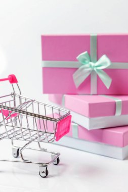 Küçük süpermarket bakkal itme cart pembe hediye kutusu beyaz arka plan üzerinde izole ile oyuncak alışveriş için. Satılık Alışveriş Merkezi Pazar dükkanı tüketici kavramı satın. Kopya alanı