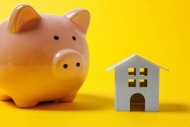 Sadece tasarım minyatür oyuncak ev, kumbara sarı renkli şık modern moda arka plan üzerinde izole. İpotek özelliği sigorta hayalinizdeki ev yatırım kredisi kavramı bankacılık. Kopya alanı