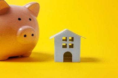 Sadece tasarım minyatür oyuncak ev, kumbara sarı renkli şık modern moda arka plan üzerinde izole. İpotek özelliği sigorta hayalinizdeki ev yatırım kredisi kavramı bankacılık. Kopya alanı