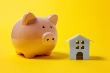 Sadece tasarım minyatür oyuncak ev, kumbara sarı renkli şık modern moda arka plan üzerinde izole. İpotek özelliği sigorta hayalinizdeki ev yatırım kredisi kavramı bankacılık. Kopya alanı