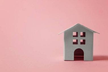 Sadece pembe pastel renkli şık arka plan üzerinde izole minyatür beyaz oyuncak ev tasarım. Mortgage Emlak sigorta rüya ev concept. Kopya alanı