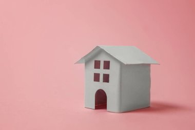 Sadece pembe pastel renkli şık arka plan üzerinde izole minyatür beyaz oyuncak ev tasarım. Mortgage Emlak sigorta rüya ev concept. Kopya alanı