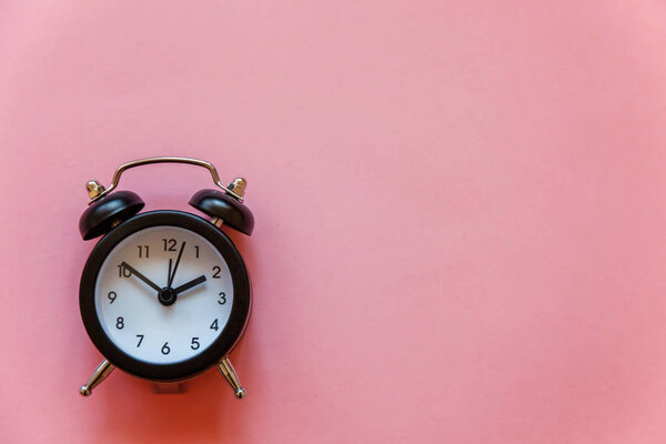 Ringing twin bell vintage classic alarm clock Isolated on pink pastel colourful trendy background. Rest hours, time of life, good morning night, wake up, awake concept. Flat lay, top view, copy space