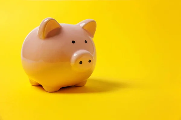 Pink piggy bank isolated on yellow colourful trendy modern fashion background. Saving investment budget wealth business retirement, financial, money, banking concept. Copy space