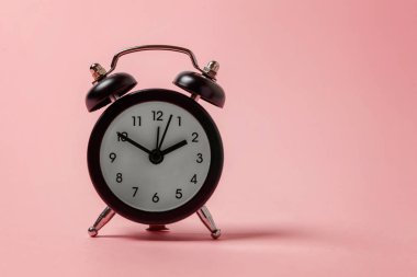 İki Yataklı çan vintage klasik çalar saat göl kenarında pembe pastel renkli arka plan üzerinde zil. Yaşam süresi saat sabah gece iyi dinlen uyanık kavramı uyandır. Düz yatıyordu üstten görünüm kopya alanı