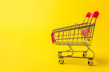 Sarı renkli şık modern moda arka plan üzerinde izole tekerlekli oyuncak alışveriş bakkal itme sepeti küçük süpermarket. Satılık Alışveriş Merkezi Pazar dükkanı tüketici kavramı satın. Kopya alanı