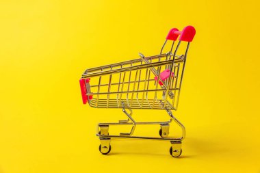 Sarı renkli şık modern moda arka plan üzerinde izole tekerlekli oyuncak alışveriş bakkal itme sepeti küçük süpermarket. Satılık Alışveriş Merkezi Pazar dükkanı tüketici kavramı satın. Kopya alanı