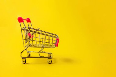 Sarı renkli şık modern moda arka plan üzerinde izole tekerlekli oyuncak alışveriş bakkal itme sepeti küçük süpermarket. Satılık Alışveriş Merkezi Pazar dükkanı tüketici kavramı satın. Kopya alanı