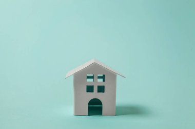 Sadece tasarım mavi pastel renkli şık arka plan üzerinde izole bir minyatür beyaz oyuncak ev. Mortgage Emlak sigorta rüya ev concept. Kopya alanı