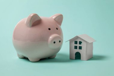 Mavi pastel renkli şık arka plan üzerinde izole sadece tasarımı ile minyatür oyuncak ev, kumbara izole. İpotek özelliği sigorta hayalinizdeki ev yatırım kredisi kavramı bankacılık. Kopya alanı