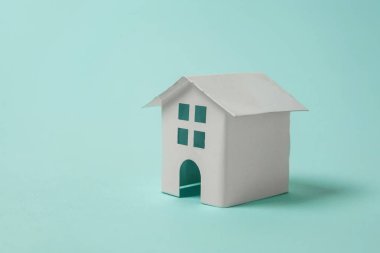 Sadece tasarım mavi pastel renkli şık arka plan üzerinde izole bir minyatür beyaz oyuncak ev. Mortgage Emlak sigorta rüya ev concept. Kopya alanı