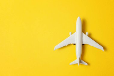 Sade bir şekilde yatıyordu tasarım minyatür oyuncak model uçak sarı renkli kağıt trendy arka plan üzerinde düz. Uçak tatil yaz hafta sonu deniz macera seyahat yolculuk bilet Tur kavramı ile seyahat