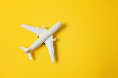 Sade bir şekilde yatıyordu tasarım minyatür oyuncak model uçak sarı renkli kağıt trendy arka plan üzerinde düz. Uçak tatil yaz hafta sonu deniz macera seyahat yolculuk bilet Tur kavramı ile seyahat