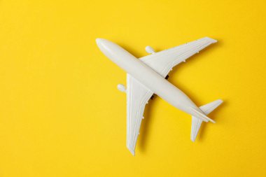 Sade bir şekilde yatıyordu tasarım minyatür oyuncak model uçak sarı renkli kağıt trendy arka plan üzerinde düz. Uçak tatil yaz hafta sonu deniz macera seyahat yolculuk bilet Tur kavramı ile seyahat