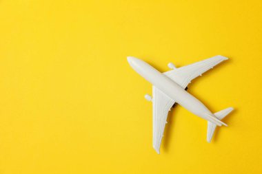 Sade bir şekilde yatıyordu tasarım minyatür oyuncak model uçak sarı renkli kağıt trendy arka plan üzerinde düz. Uçak tatil yaz hafta sonu deniz macera seyahat yolculuk bilet Tur kavramı ile seyahat