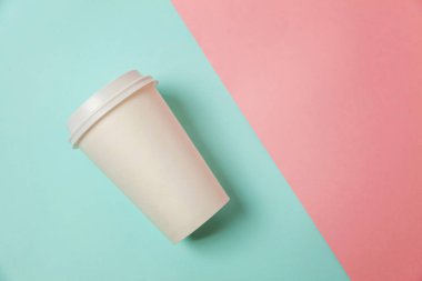 Sadece mavi pembe pastel renkli trendy zemin üzerinde yatıyordu tasarım kağıt kahve Kupası düz. Paket servisi olan restoran içki kabı. Günaydın uyanık kavramı uyandır. İçki mockup şablonu. Üstten görünüm kopya alanı