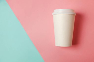 Sadece mavi pembe pastel renkli trendy zemin üzerinde yatıyordu tasarım kağıt kahve Kupası düz. Paket servisi olan restoran içki kabı. Günaydın uyanık kavramı uyandır. İçki mockup şablonu. Üstten görünüm kopya alanı
