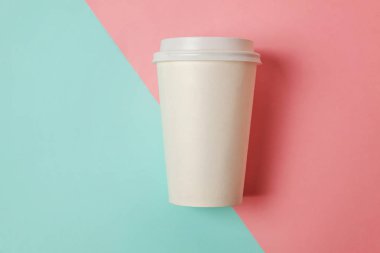 Sadece mavi pembe pastel renkli trendy zemin üzerinde yatıyordu tasarım kağıt kahve Kupası düz. Paket servisi olan restoran içki kabı. Günaydın uyanık kavramı uyandır. İçki mockup şablonu. Üstten görünüm kopya alanı