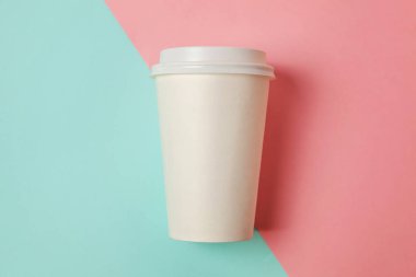Sadece mavi pembe pastel renkli trendy zemin üzerinde yatıyordu tasarım kağıt kahve Kupası düz. Paket servisi olan restoran içki kabı. Günaydın uyanık kavramı uyandır. İçki mockup şablonu. Üstten görünüm kopya alanı