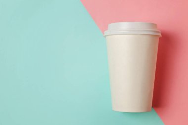 Sadece mavi pembe pastel renkli trendy zemin üzerinde yatıyordu tasarım kağıt kahve Kupası düz. Paket servisi olan restoran içki kabı. Günaydın uyanık kavramı uyandır. İçki mockup şablonu. Üstten görünüm kopya alanı