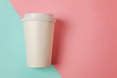 Sadece mavi pembe pastel renkli trendy zemin üzerinde yatıyordu tasarım kağıt kahve Kupası düz. Paket servisi olan restoran içki kabı. Günaydın uyanık kavramı uyandır. İçki mockup şablonu. Üstten görünüm kopya alanı