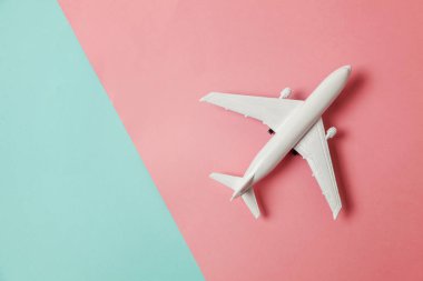Sade bir şekilde yatıyordu tasarım minyatür oyuncak model uçak mavi ve pembe pastel renkli kağıt trendy geometrik arka plan üzerinde düz. Uçak tatil yaz hafta sonu deniz macera seyahat kavramı ile seyahat