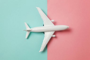 Sade bir şekilde yatıyordu tasarım minyatür oyuncak model uçak mavi ve pembe pastel renkli kağıt trendy geometrik arka plan üzerinde düz. Uçak tatil yaz hafta sonu deniz macera seyahat kavramı ile seyahat