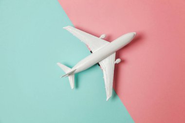 Sade bir şekilde yatıyordu tasarım minyatür oyuncak model uçak mavi ve pembe pastel renkli kağıt trendy geometrik arka plan üzerinde düz. Uçak tatil yaz hafta sonu deniz macera seyahat kavramı ile seyahat