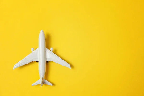 简单平坦的平面设计微型玩具模型飞机上的黄色五颜六色的纸时尚背景 乘坐飞机度假暑假海险旅行旅游票务旅游概念 — 图库照片
