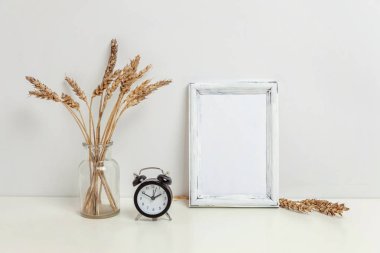 Dikey çerçeve mockup vahşi çavdar kokulu beyaz duvarının yakınında cam vazoda. Boş çerçeve tanıtım tasarım için sahte. Modern sanat için şablon çerçeveleme. Hygge İskandinav tarzı doğal Eko ev dekorasyonu