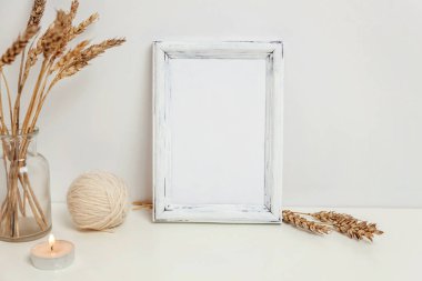 Dikey çerçeve mockup vahşi çavdar kokulu beyaz duvarının yakınında cam vazoda. Boş çerçeve tanıtım tasarım için sahte. Modern sanat için şablon çerçeveleme. Hygge İskandinav tarzı doğal Eko ev dekorasyonu