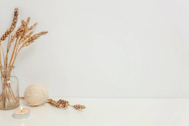 Doğal Eko ev dekor cam vazo mum yünü beyaz duvarının yakınında vahşi çavdar kokulu. Minimalizm iç dekorasyon yaşam tarzı arka plan. Hygge İskandinav tarzı kavramı. Metin için yer yer kopyalayın