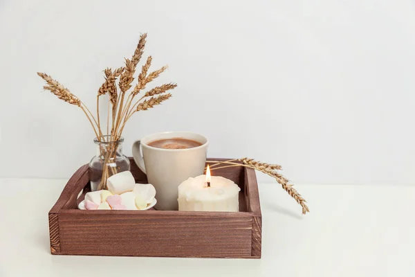 Natural eco home decor with cup coffee marshmallow candle on wooden tray. Early morning breakfast lifestyle background. Interior decoration with hot drink mug. Hygge scandinavian style copy space