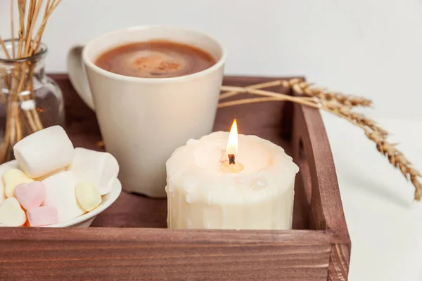 Natural eco home decor with cup coffee marshmallow candle on wooden tray. Early morning breakfast lifestyle background. Interior decoration with hot drink mug. Hygge scandinavian style copy space