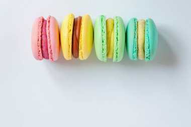 Tatlı badem renkli pembe, mavi, sarı, yeşil macarons beyaz arka plan üzerinde