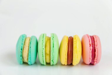 Tatlı badem renkli pembe, mavi, sarı, yeşil macarons beyaz arka plan üzerinde
