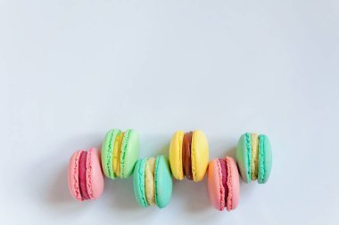 Tatlı badem renkli pembe, mavi, sarı, yeşil macarons beyaz arka plan üzerinde
